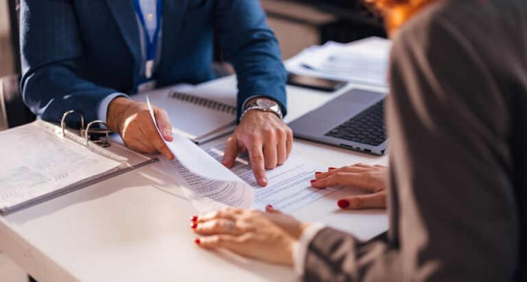 The real estate agent closes the deal with the client and they sign the contract